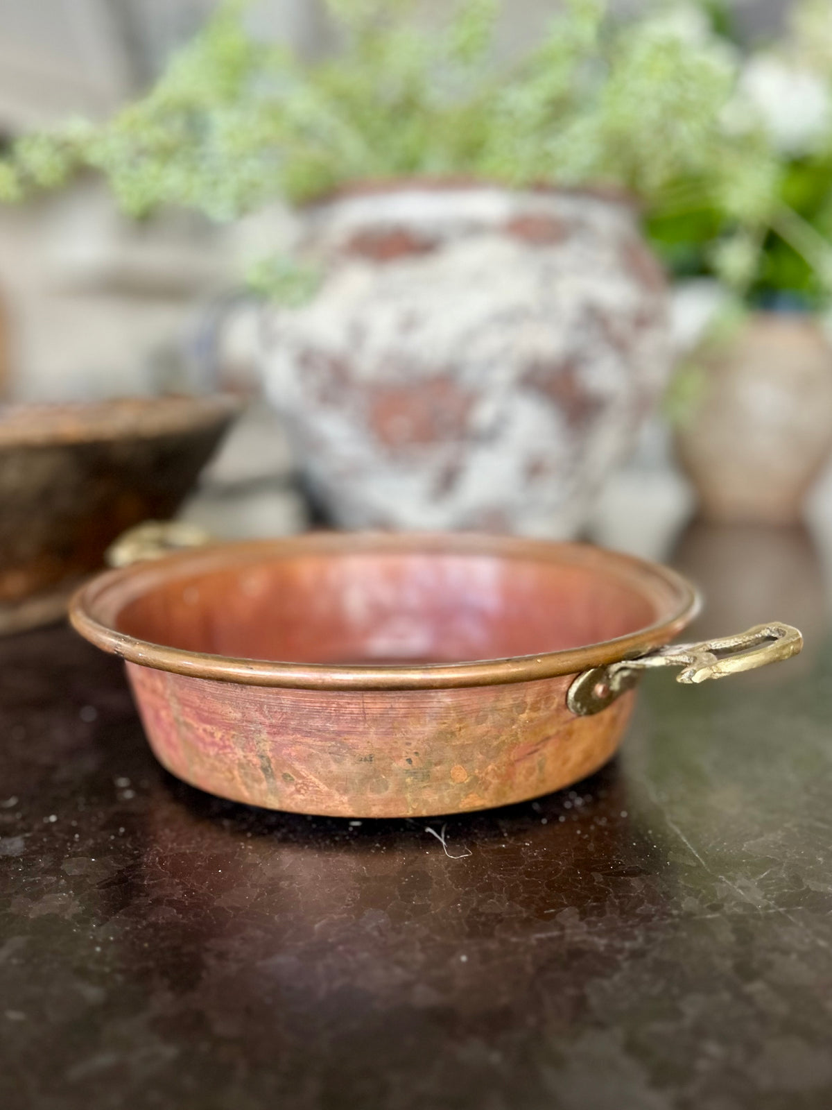 Early 20th-century French copper escargot pan with riveted brass handles and rich, timeworn patina.
