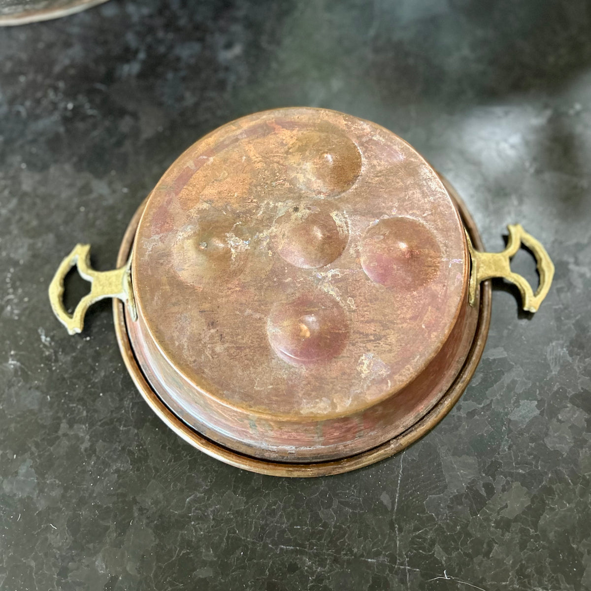Early 20th-century French copper escargot pan with riveted brass handles and rich, timeworn patina.