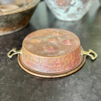 Early 20th-century French copper escargot pan with riveted brass handles and rich, timeworn patina.